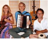 Photo of David holding an accordian, with Gary Waryan holding tablas and Dalyce Elliot holding a violin